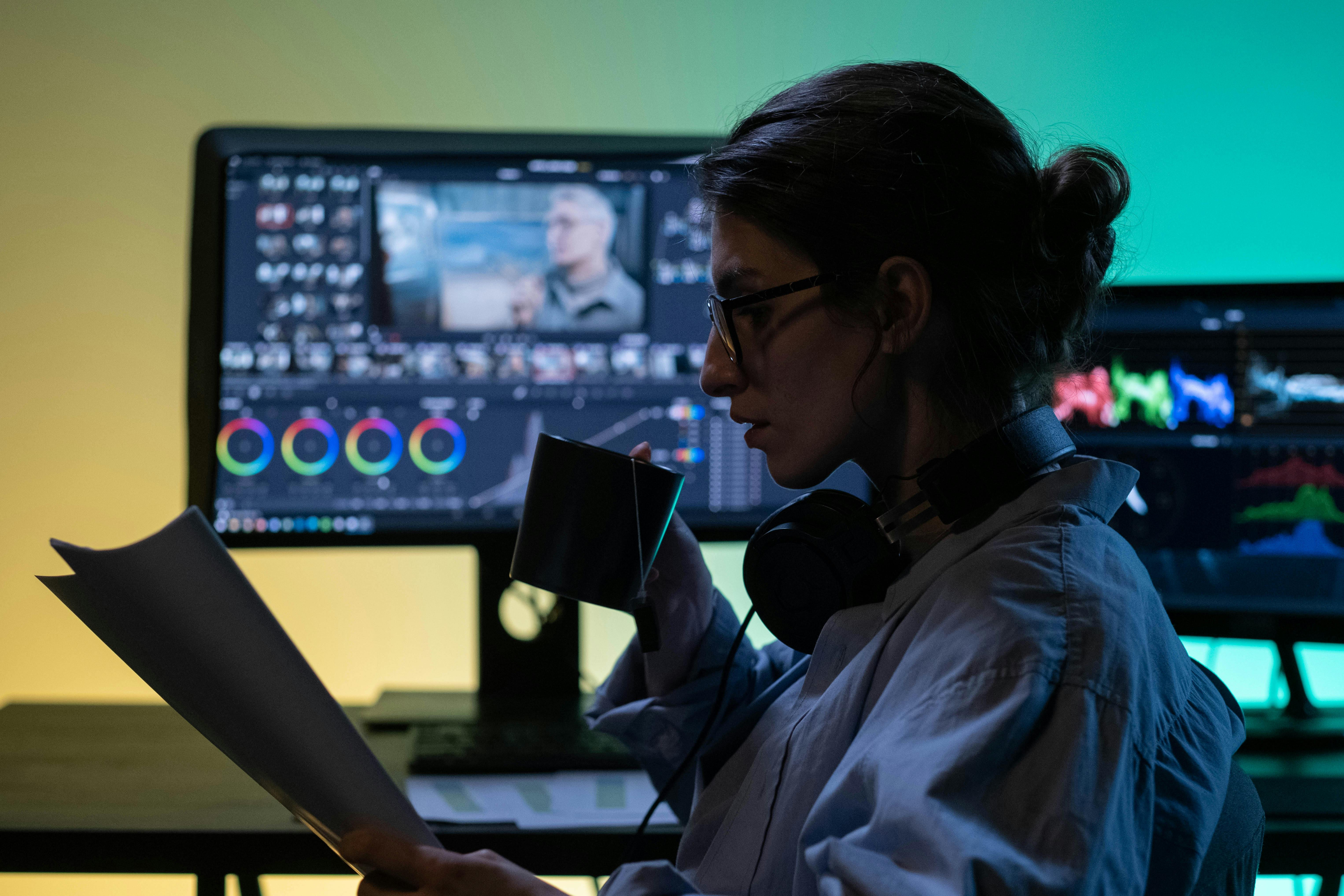 A young person wearing headphones and using a laptop.